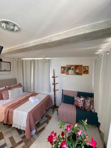a bedroom with two beds and a couch at Apêzinho Vidigal - RJ in Rio de Janeiro