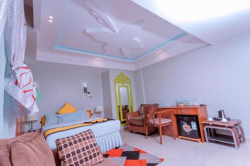 a room with a bed and a table and a couch at Selig Hotel in Moshi