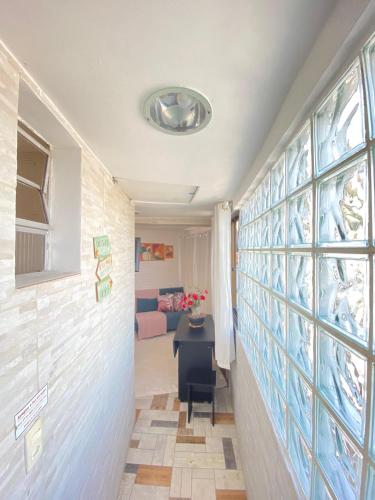a hallway with a room with a table and a couch at Apêzinho Vidigal - RJ in Rio de Janeiro