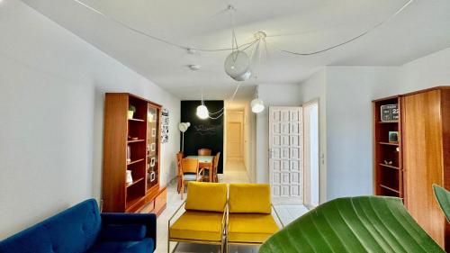 a living room with blue and yellow chairs and a table at Le Family Palms Private Oasis with Terrace & BBQ in Playa Honda