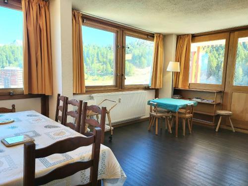une pièce avec une table, des chaises et des fenêtres dans l'établissement Appartement spacieux à 2 chambres pour 8 personnes - Plagne Centre, proche des pistes, WIFI - FR-1-351-11, à La Plagne