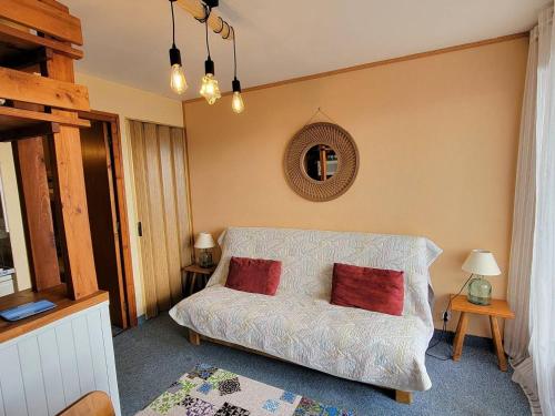 sypialnia z łóżkiem z 2 czerwonymi poduszkami w obiekcie Studio 4 pers, balcon sud, parking, résidence calme - FR-1-393-161 w mieście Saint-Michel-de-Chaillol
