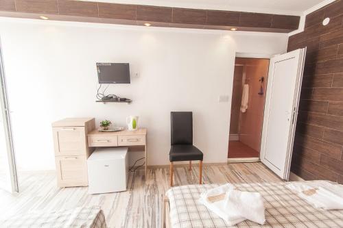 a bedroom with a desk and a chair in a room at Rooms and Apartments Milana in Bar