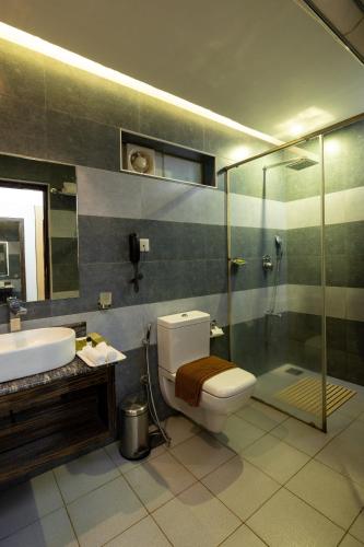 a bathroom with a toilet and a sink and a shower at Casa Rio Resorts Athirappilly in Athirappilly