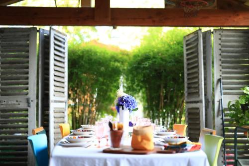 einen Tisch mit Teller und Tassen und eine Vase Blumen in der Unterkunft Gîte Un chalet en Sidobre in Lacrouzette
