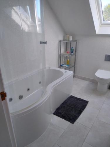 un bagno bianco con vasca e WC di farm cottage with hottub a Ferrensby