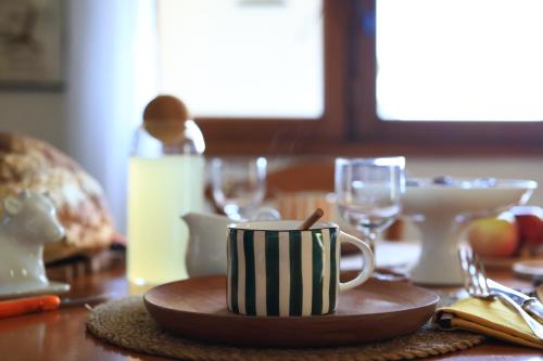 ein Tisch mit einer Kaffeetasse und Gläsern darauf in der Unterkunft Gîte Un chalet en Sidobre in Lacrouzette