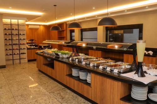 a buffet line in a restaurant with food at Hotel Metrópole in São Lourenço