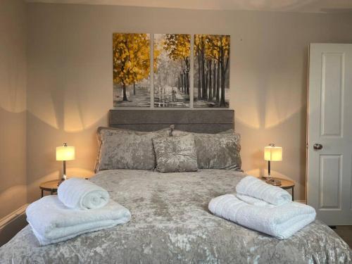 een slaapkamer met een bed met handdoeken erop bij Townhouse in Belfast in Belfast