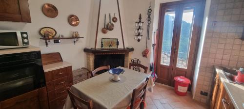 a kitchen with a table and a fireplace in it at Casa Alessandro in Pacentro
