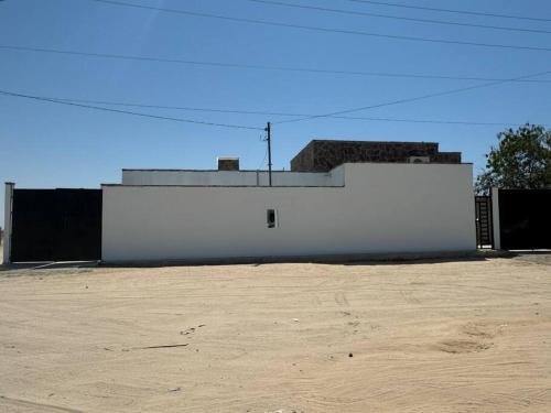 a white building with a dirt field in front of it at Spacious 3-Bed, 2-Bath Home in Puerto Peñasco