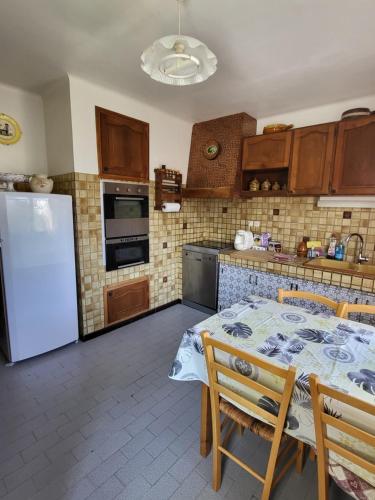 une cuisine avec une table et un réfrigérateur blanc dans l'établissement Appartement Villa, à La Garde