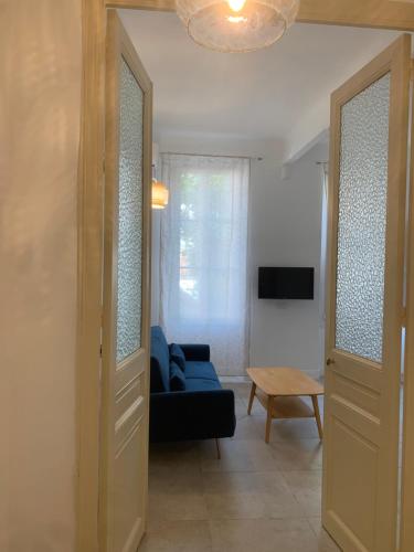 un salon avec un canapé bleu et une table dans l'établissement Cœur du Prado À deux, pas des Plage et du stade plein centre, à Marseille