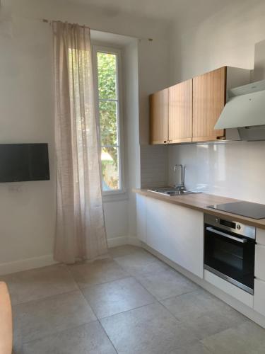 une cuisine avec un évier et une fenêtre dans l'établissement Cœur du Prado À deux, pas des Plage et du stade plein centre, à Marseille