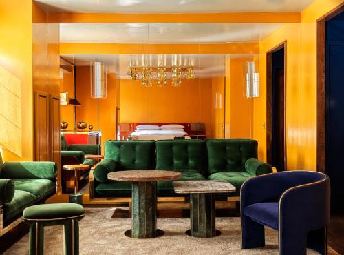 a living room with a green couch and a bed at The Manner, The Unbound Collection by Hyatt in New York