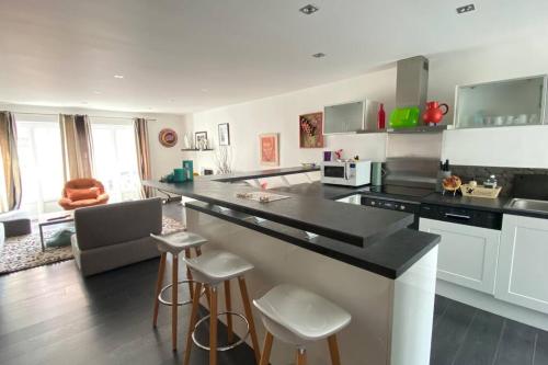 une cuisine avec un comptoir et des tabourets dans une pièce dans l'établissement Appart T3 terrasse centre ville et plage, à Le Touquet-Paris-Plage