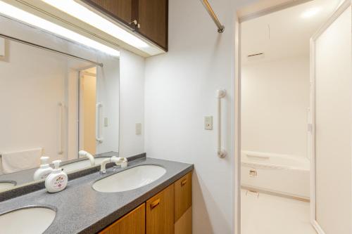a bathroom with two sinks and a mirror at Stayinn Hakata - Vacation Rental in Fukuoka