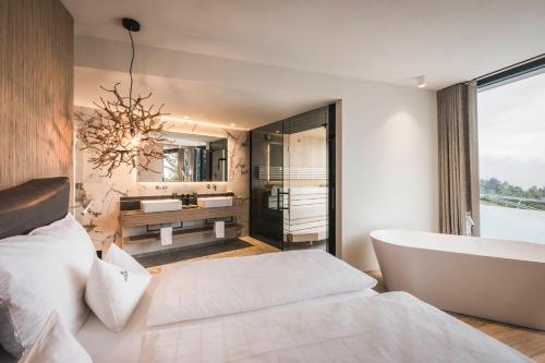 a bedroom with a bed and a tub and a sink at Schenna Resort in Schenna