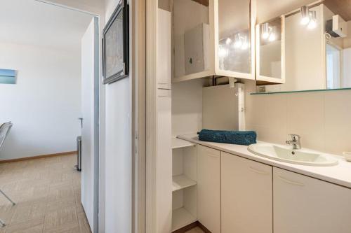 une salle de bain blanche avec un lavabo et un miroir dans l'établissement La Lagure, à Courseulles-sur-Mer