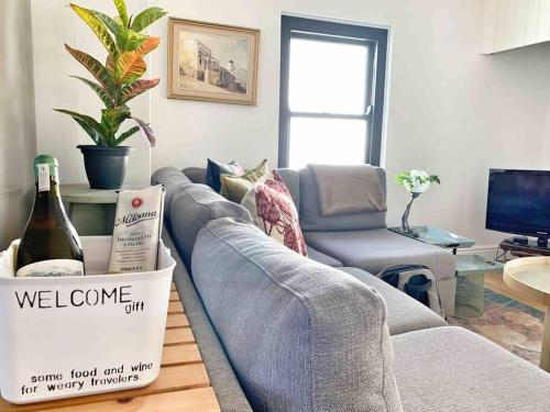 a living room with a couch with a bottle of wine at The Town House - Lower Knysna Central in Knysna