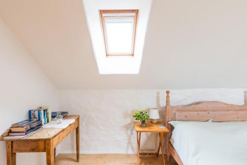 a bedroom with a bed and a desk and a window at Harmony in Goodwick