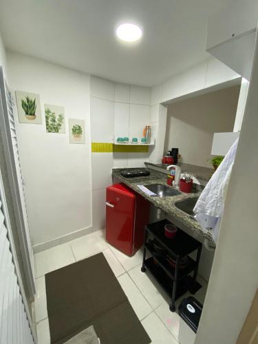 a small kitchen with a counter and a red refrigerator at Apêzinho Vidigal - RJ in Rio de Janeiro