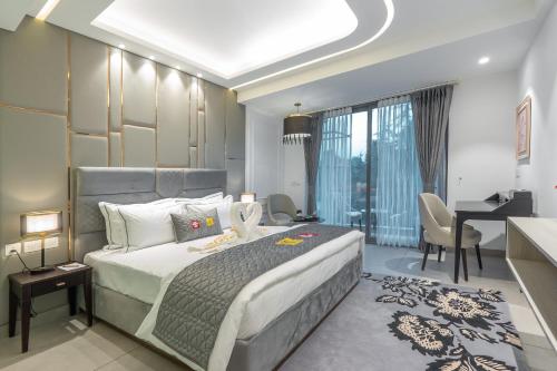 a bedroom with a bed and a desk and a room with a desk at Mastiff Select Mandavya Dharamkot, McLeodganj in Dharamshala