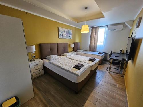a bedroom with two beds and a desk in it at Royal Apartments & Rooms in Zagreb