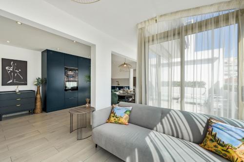un salon avec un canapé et une grande fenêtre dans l'établissement Hypercentre - Palais - Croisette - Plage - CI, à Cannes