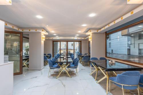 een eetkamer met blauwe stoelen en een tafel bij Safari Otel in Antalya