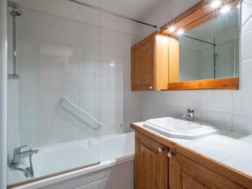 une salle de bain avec un lavabo, une baignoire et un miroir dans l'établissement Charmant appartement 2 chambres à Méribel, proche pistes et commerces - FR-1-355-139, à Méribel
