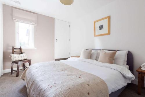 a white bedroom with a bed and a chair at Lux Countryside Haven Mins to Beach Garden in Birdham