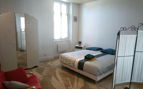 une chambre blanche avec un lit et une fenêtre dans l'établissement Chez Karine à Lencouacq, à Lencouacq