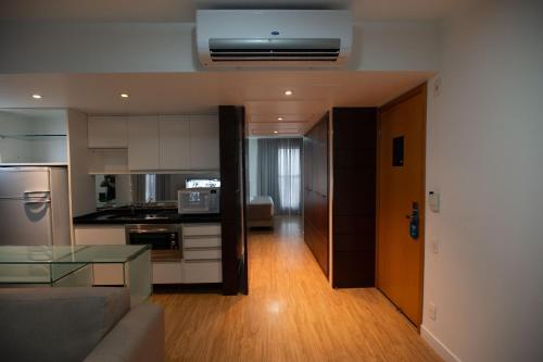 a kitchen and a living room with a couch and a table at H2 Platinum Lourdes in Belo Horizonte