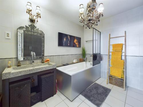 une salle de bain avec une baignoire, un lavabo et un miroir dans l'établissement Loft design chez Lili aux portes de Paris, à Bagnolet