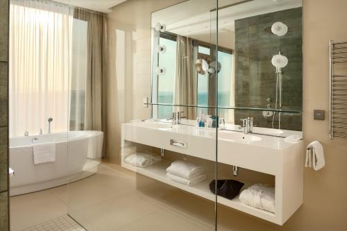 a bathroom with a tub and a sink and a mirror at Radisson Blu Resort & Spa in Split