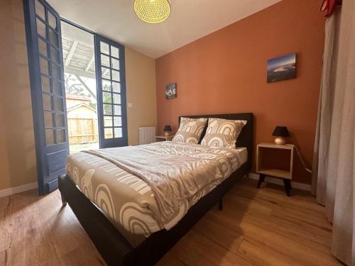 une chambre avec un lit et une grande fenêtre dans l'établissement Maison seconde ligne Lanton, à Taussat-les-Bains
