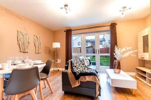 a living room with a table and chairs and a dining room at Stylish Modern Stay Prime Location Free Parking & Fast Wi-Fi in Peterborough