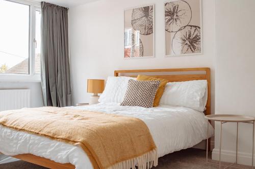 a bedroom with a bed with white sheets and pillows at Modern Bright Spacious Home in Moortown