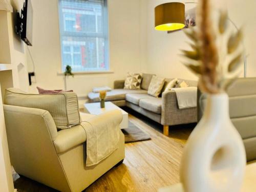 a living room with couches and a vase at Spacious Home with On-Street Parking in Cardiff