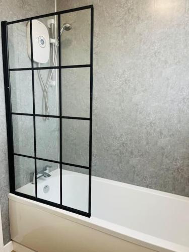 a bathroom with a shower with a sink and a mirror at Spacious Home with On-Street Parking in Cardiff