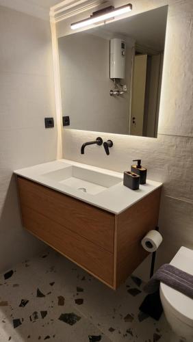 a bathroom with a sink and a mirror at Patras Aura - Old Town in Patra
