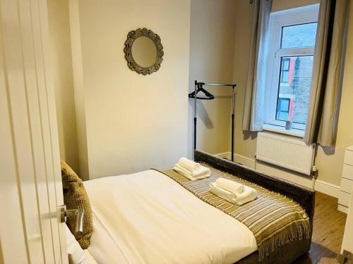 a bedroom with a bed with two towels on it at Spacious Home with On-Street Parking in Cardiff