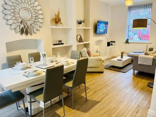 a living room with a table with chairs and a couch at Spacious Home with On-Street Parking in Cardiff