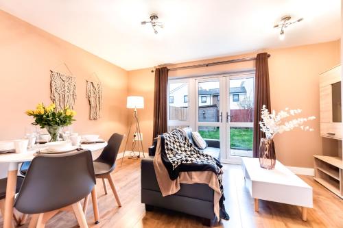 a living room with a dining room table and a dining room at Stylish Modern Stay Prime Location Free Parking & Fast Wi-Fi in Peterborough