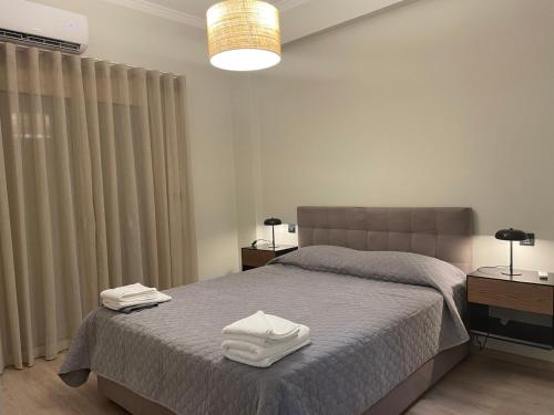 a bedroom with a bed with two towels on it at Patras Aura - Old Town in Patra