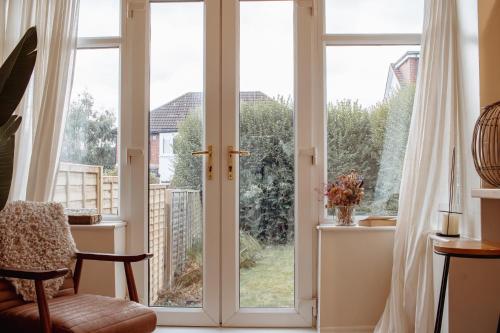ein Zimmer mit Glasschiebetüren mit Blick auf einen Garten in der Unterkunft Modern Bright Spacious Home in Moortown