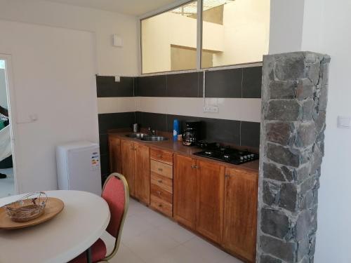 a kitchen with a table and a counter with a sink at STUDIO VUE MER - CASA da LUZ in Mindelo