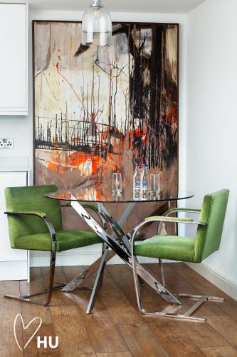 a dining room with a glass table and two green chairs at Boutique 1 Bdrm Duplex Suite on Marina 305 in Hull