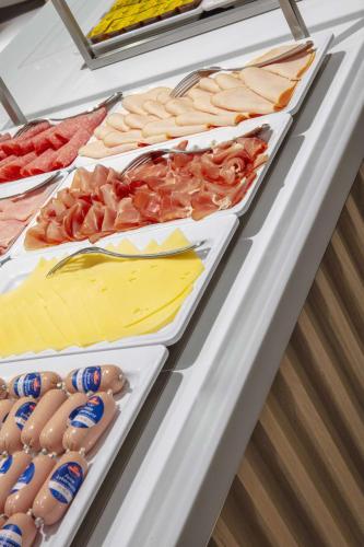 a buffet line with different types of meats and seafood at Prize by Radisson, Bremen City in Bremen